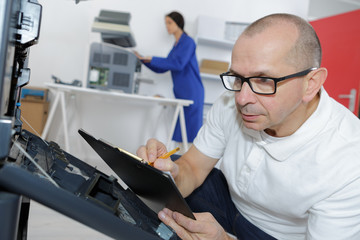 technician maintaining server on clipboard