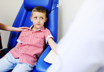 a doctor or nurse takes blood from a vein in a child of a boy. Blood chemistry