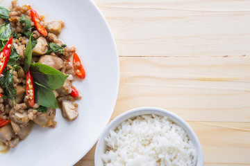 Salted pork with chili & Basil leaves and rice in plate on table, top view