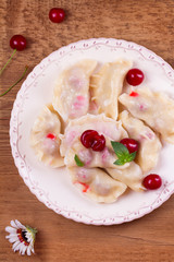 Dumplings, filled with cherries. Varenyky, vareniki, pierogi, pyrohy - popular dish in East Europe. View from above, top studio shot, vertical
