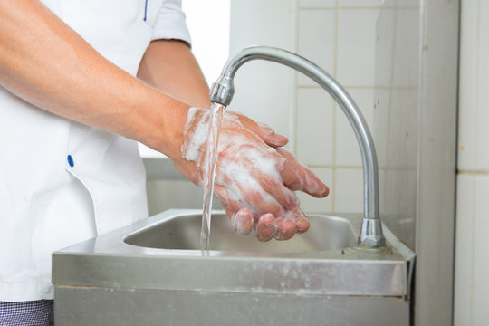 man washing hands in sink close up view