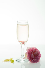 Alcoholic beverage and rose flower at restaurant.