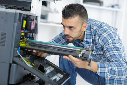 closeup shot young male technician repairing digital photocopier machine
