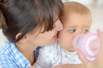 mother feeds the baby bottle