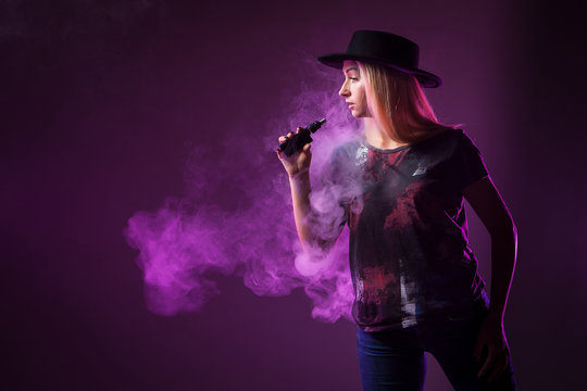 Girl in the smoke of an electronic cigarette. ( vaping ) e-cigarette.