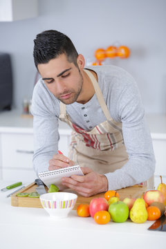 man following a recipe at home in the kitchen