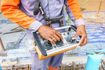 builder worker controlling trailer-mounted boom concrete pump on metal rods reinforcement of concrete casting formwork