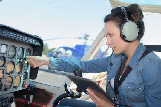 attractive woman pilotsitting in small helicopter