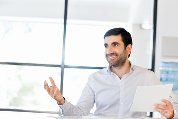 Handsome young man holding paper in office