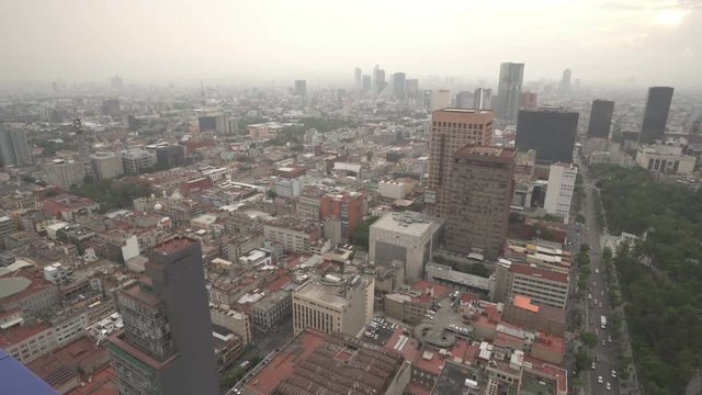 Birds-eye panoramic view to roofs of ancient houses, buildings, central square park and streets in the city at summer