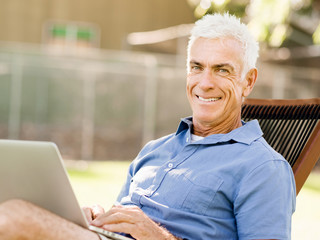 Fototapeta na wymiar Senior man with notebook sitting in the park