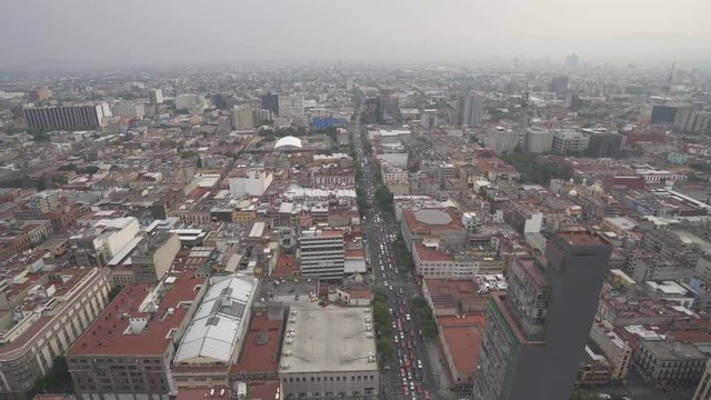 Birds-eye view to roofs of ancient houses, buildings, central square park and streets in the city at summer cloudy day