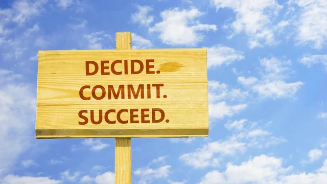 Decide, commit, succeed. Words on a wooden sign against time lapse clouds in the blue sky. 