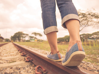 Retro style of woman walking on the railway. Travel and step concept.