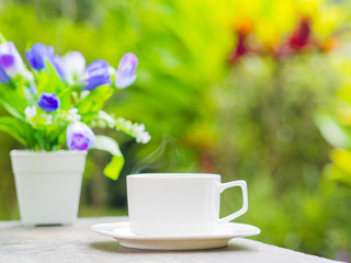 Soft focus of close up coffee cup in garden.