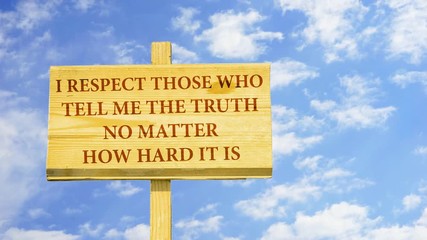 I respect those who tell me the true no matter how hard it is. Words on a wooden sign against time lapse clouds in the blue sky. 