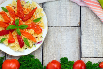 Farfalle pasta with tomatoes, peppers and herbs. Top view