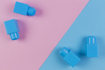 Blue plastic construction blocks on pink and blue background