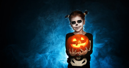 magic skeleton with  pumpkin. baby girl in costume to halloween.