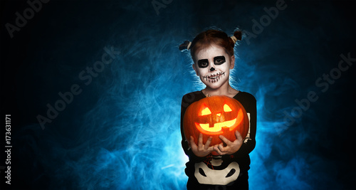 magic skeleton with  pumpkin. baby girl in costume to halloween.