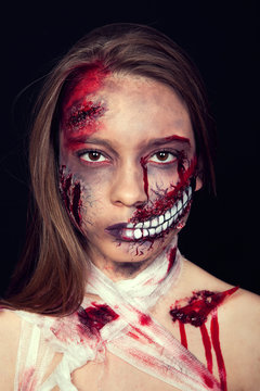 Girl with wounds on her face, bloody stains, makeup for halloween, girl