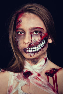Girl with wounds on her face, bloody stains, makeup for halloween, girl