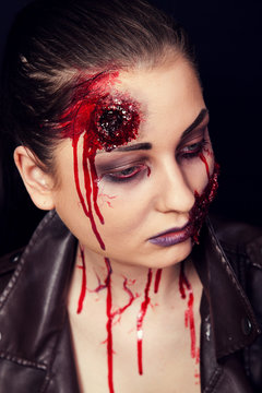 Girl with wounds on her face, bloody stains, makeup for halloween