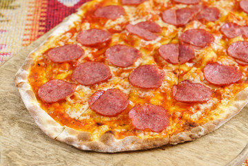 pizza with salami on the wooden board