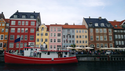 Bright beautiful facades of the buildings on the waterfront Nyhavn and the red-white ship on the water