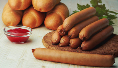 Ingredients for making homemade hot dogs. Sausages, fresh baked buns and ketchup sauce