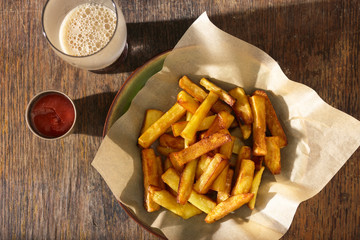 Plate of fries with ketchup and glass of dark beer