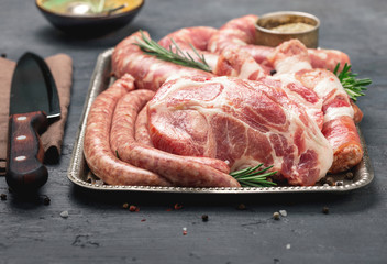 Close up raw steaks and sausages with spices