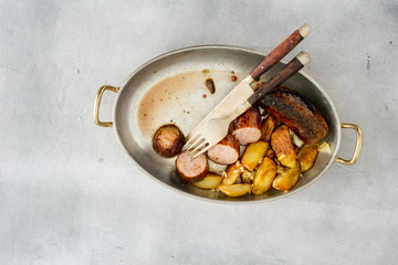 Top view fried sausages with potatoes in frying pan