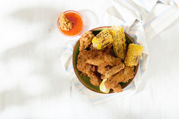 Fried chicken legs with grilled corn and red spicy sauce
