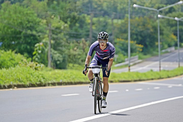 Cyclist Climb Out Of The Saddle and pedaling on the road.
Professional and his biggest passion - cyclist competing in a race.