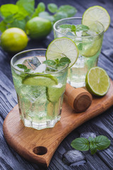 refreshing cold mojito with ice on a black wooden table