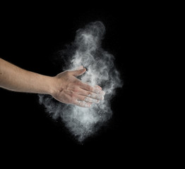 Fototapeta na wymiar Freeze motion of dust explosion in hands isolated on black background