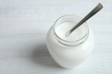 A jar with a yogurt and a spoon