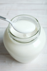 A jar with a yogurt and a spoon