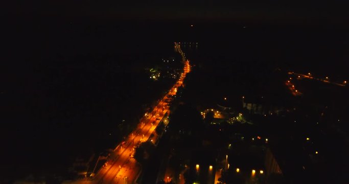 Aerial shot at night of coastal city Palanga lights with view of sea bridge