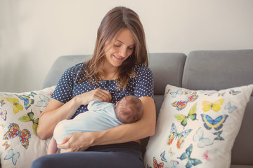 Young mother breastfeeding  her newborn baby boy © Tomsickova