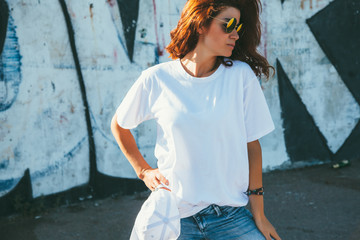 Model wearing plain tshirt and sunglasses posing over street wall - obrazy, fototapety, plakaty