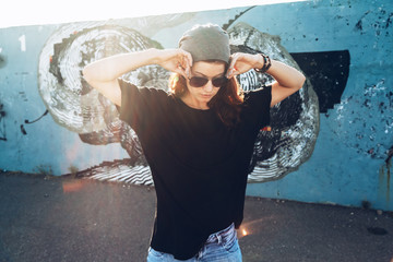 Model wearing plain tshirt and sunglasses posing over street wall - 173654928