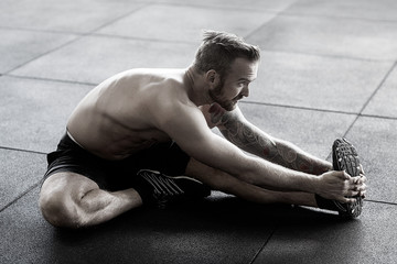 Man Doing Stretching Exercise In Gym