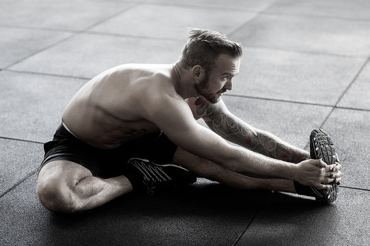 Man Doing Stretching Exercise In Gym