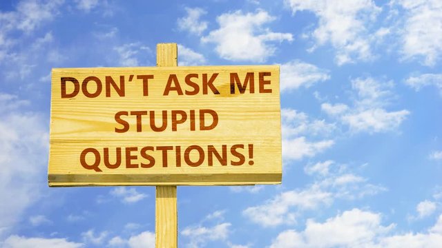 Don't ask me stupid questions. Words on a wooden sign against time lapse clouds in the blue sky.