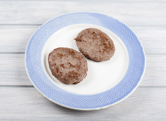 Burgers on blue plate on wooden table. Food.
