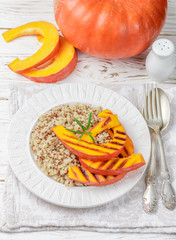 Quinoa with roasted pumpkin in a white plate. Cold or hot salad. Diet. Selective focus