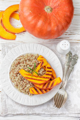 Quinoa with roasted pumpkin in a white plate. Cold or hot salad. Diet. Selective focus