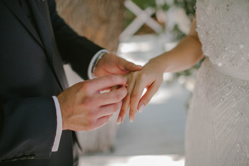 Obraz na płótnie Canvas The groom wears a wedding ring to the bride